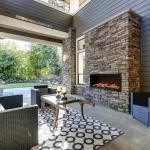 Well designed covered patio boasts stone fireplace